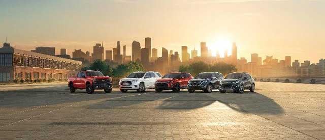 Photo of 5 new vehicles exterior with downtown and sunrise