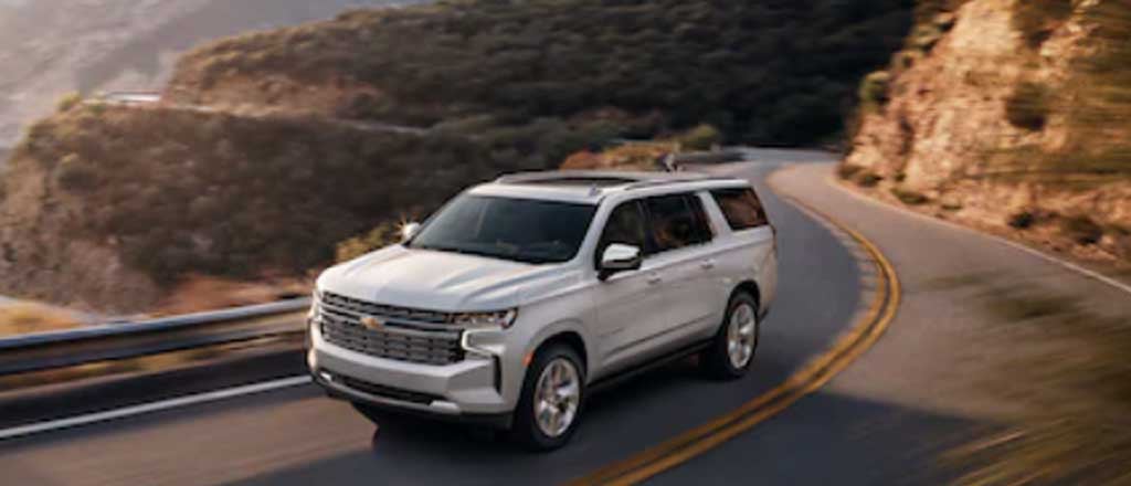 2025 Chevrolet Tahoe driving on road in mountain exterior